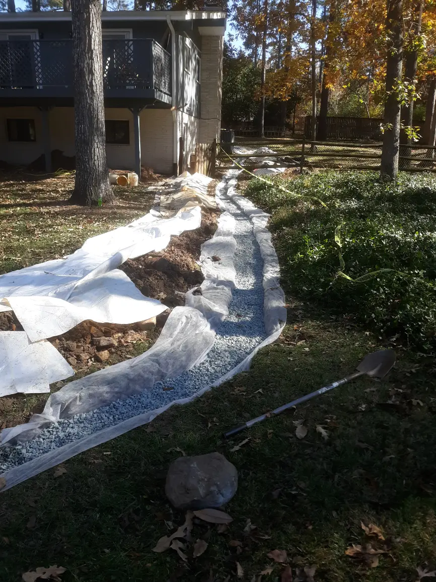Technician inspecting and maintaining a home drainage system